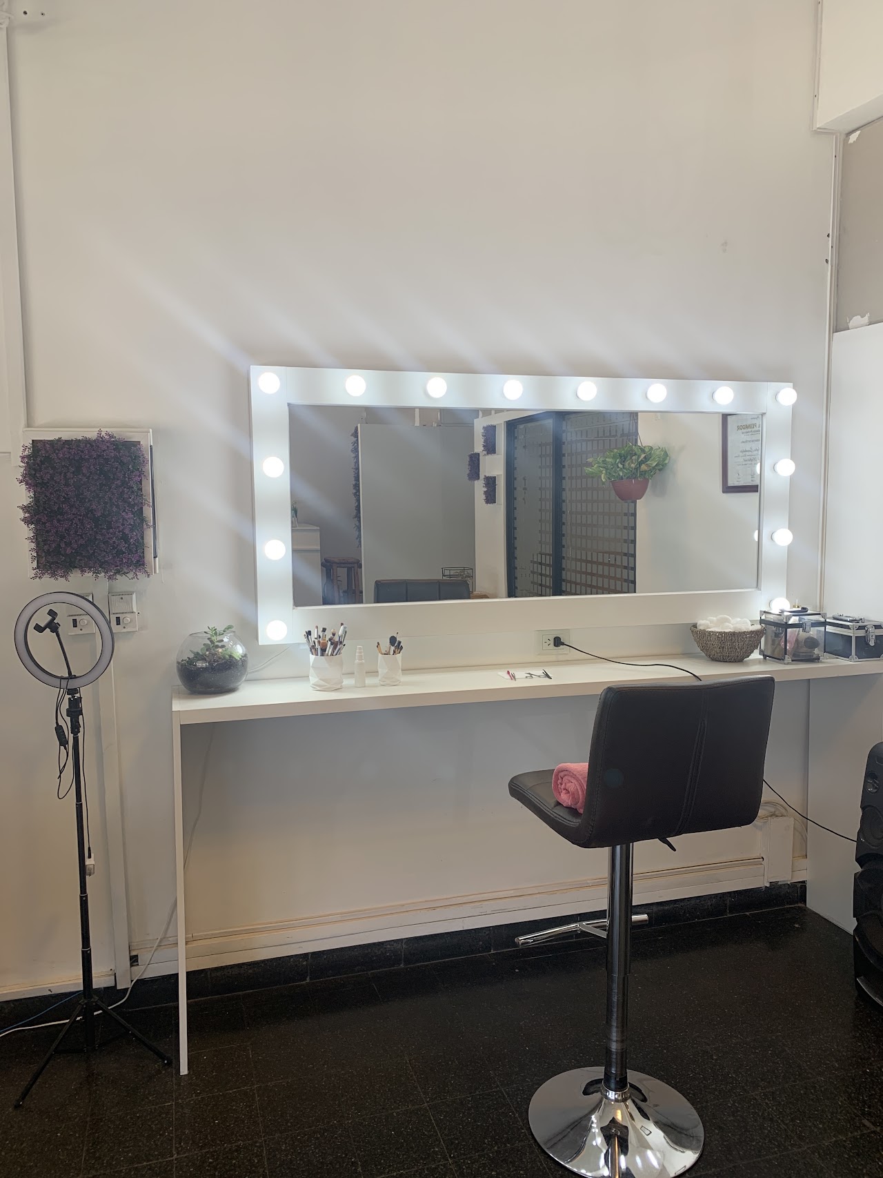 Estación de maquillaje con espejo tipo Hollywood iluminado en Blossom Beauty Bar, Neuquén